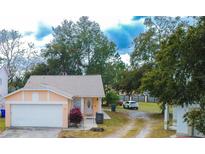 Cute one-story house with a white garage door and red plants at 1100 Lowry Ave # 7, Lakeland, FL 33801