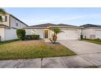 Single-story home with gray exterior, attached garage, and landscaped lawn at 13881 Rushing Creek Run, Orlando, FL 32824