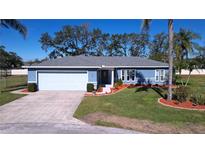 Single-story home with blue exterior, landscaped yard, and attached garage at 1126 Shadowbrook N Dr, Lakeland, FL 33813