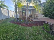 Charming home featuring beautiful landscaping, palm trees, and a quaint front porch swing at 4035 Solamor St, Lakeland, FL 33810