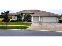 Two-story house with a three-car garage and manicured lawn at 2912 Sweetspire Cir, Kissimmee, FL 34746