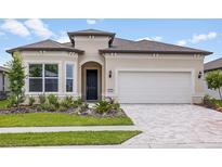 Charming home featuring a well-manicured lawn, tasteful landscaping, and a brick-paved driveway at 5222 Sw 88Th Cir, Ocala, FL 34481