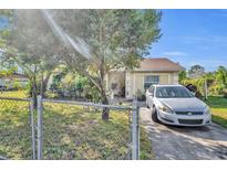 House exterior showcasing a well-maintained lawn and chain link fence at 4214 Brittany Rd, Orlando, FL 32808