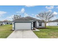 Charming single Gathering home featuring a two-car garage, a well-manicured lawn, and delightful curb appeal at 4698 Harts Brook Ln, Mulberry, FL 33860
