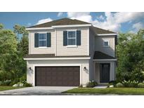 Two-story house with dark brown garage door and light beige siding at 5721 Gingham Dr, Kissimmee, FL 34758