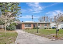 Charming single-story home with a brick accent, green lawn, and a long, inviting driveway at 942 Hanover Ave, Winter Park, FL 32789