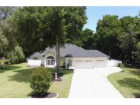 Single-story home with two-car garage, driveway, and mature landscaping at 36320 Piney Ridge Blvd, Fruitland Park, FL 34731