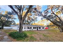 Newly renovated home with a white exterior, black windows, and landscaping at 3720 Willis Rd, Mulberry, FL 33860