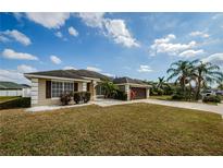 Charming single-story home boasts a manicured lawn, a two-car garage, and attractive landscaping at 8779 Fort Socrum Village Way, Lakeland, FL 33810