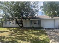 White brick ranch house with a single car garage and mature tree in the front yard at 4534 Lemans Dr, Orlando, FL 32808