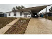Ranch style home with carport and mature landscaping at 1106 Avenue N, Haines City, FL 33844