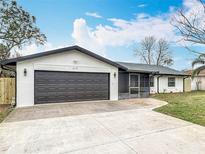 Charming single-story home with gray garage door, fresh white paint, and a well-maintained front yard at 610 Moonpenny Cir, Port Orange, FL 32127