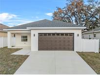 Charming single Gathering home featuring a gray roof, brown garage door, and a large driveway at 833 Texas Ave, Lakeland, FL 33815