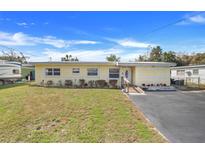 Charming yellow single-story home with a well-maintained lawn and accessible ramp leading to the front door at 1220 George St, Winter Springs, FL 32708