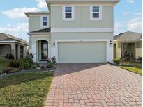 Charming two-story home featuring a brick driveway and attached two-car garage at 6973 Wilson Pasture Ave, Groveland, FL 34736