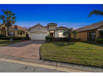 Charming single-Gathering home featuring a two-car garage, well-manicured lawn, and tropical landscaping at 1713 Altavista Cir, Lakeland, FL 33810