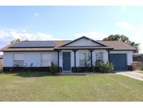 Charming single-story home featuring solar panels, a covered front porch, and a well-maintained lawn at 17 Trotters Cir, Kissimmee, FL 34743