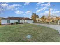 A single-story home with a white exterior, a well-maintained lawn, and an attached garage at 3290 Big Valley Dr, Lakeland, FL 33812
