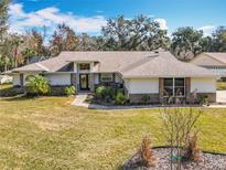 Charming single-story home with a well-manicured lawn, inviting entryway, and lush landscaping at 3931 Tano Dr, Ormond Beach, FL 32174