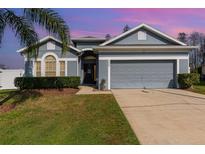 Charming single-story home with a manicured lawn, two-car garage, and freshly painted exterior at 339 Magical Way, Kissimmee, FL 34744
