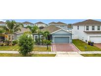 Charming single-Gathering home with a well-manicured lawn, palm trees, and a brick driveway at 648 Bloom Ter, Davenport, FL 33836