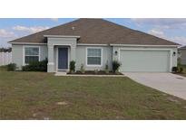 Charming single Gathering home featuring a well manicured lawn, and a two car garage at 512 Central Ridge Ln, Frostproof, FL 33843
