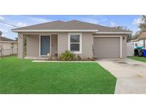 Charming single-story home with a well-maintained lawn, a blue door, and a one car garage at 1426 Powhatan Ct, Lakeland, FL 33805