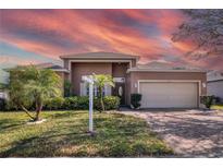 Inviting exterior showcasing a well-manicured lawn and lush landscaping at 3890 Wood Thrush Dr, Kissimmee, FL 34744