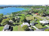 Scenic aerial view of a lakefront property surrounded by lush greenery at 917 E Valencia St, Lakeland, FL 33805