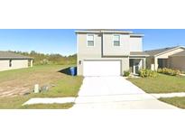 Two-story home featuring a two car garage, well-maintained lawn, and a classic siding exterior at 1753 Eagle Hammock Blvd, Eagle Lake, FL 33839