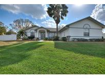 Charming home with well-manicured lawn, mature landscaping, and inviting entrance at 6677 Englelake Dr, Lakeland, FL 33813