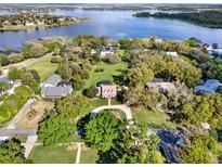 Scenic aerial view showcasing the home's large lot, mature trees, circular drive, and beautiful landscaping at 17416 Magnolia Island Blvd, Clermont, FL 34711