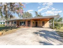 Charming single-story home with mature trees, covered parking, and a traditional brick facade at 800 22Nd Nw St, Winter Haven, FL 33881