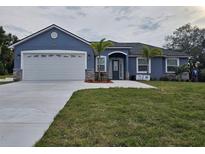 Charming single-story home boasts a well-manicured lawn and a two car garage at 1264 Buckeye Ne Rd, Winter Haven, FL 33881