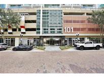 Exterior view of the 101 Eola Building showing the entrance and surrounding brick-paved street at 101 S Eola Dr # 813, Orlando, FL 32801