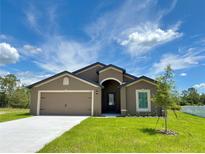 Charming single-story home featuring a two-car garage and well-manicured lawn at 409 Ashbury Way, Poinciana, FL 34759