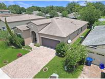 Charming single-story home showcasing a well-manicured lawn and brick driveway at 9362 Oglethorpe Dr, Groveland, FL 34736