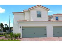 Charming two-story home featuring a two-car garage, red tile roof, neutral siding and a well-manicured front yard at 628 Bay Leaf Dr, Poinciana, FL 34759