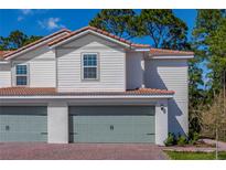 Charming home featuring a two-car garage, red brick driveway, and light gray trim at 571 Bay Leaf Dr, Poinciana, FL 34759