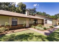 Inviting single-story home features a well-manicured lawn, brick accents, and neutral siding at 290 Ne 51St Ave, Ocala, FL 34470