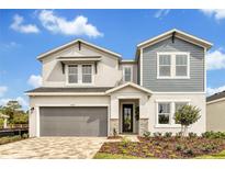 Charming two-story home featuring a gray and white exterior, covered entry, and a two-car garage at 5789 Timber Meadow Way, St Cloud, FL 34771