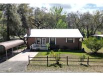 Charming single-story home with a white-trimmed porch and a convenient carport at 9461 Cr 657, Bushnell, FL 33513