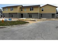 New two-story townhomes feature a yellow facade with grey accents and professional signage at 222 Carpenters Way # 68, Lakeland, FL 33805