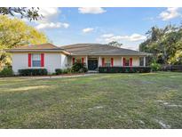 Charming single-story home featuring a well-manicured lawn and inviting front porch with vibrant red shutters at 5261 Waterwood Dr, Bartow, FL 33830