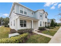 Charming townhome with light blue and white exterior, well-manicured lawn, and inviting front porch at 1324 Painted Bunting Ave, Oakland, FL 34787