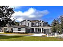 Beautiful two-story home featuring gray siding, a well-manicured lawn, and a three-car garage at 6488 Sw 78Th Ct, Ocala, FL 34474