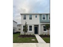 Charming two-story townhouse with manicured lawn and inviting entrance at 3146 Skyline Loop, Kissimmee, FL 34758