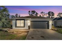 Charming single-story home featuring a two-car garage and well-maintained front yard at dusk at 5152 Belmont Park Way, Mulberry, FL 33860