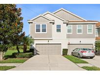 A charming townhouse with a two car garage, well maintained landscaping, and a concrete driveway at 9147 Shepton St, Orlando, FL 32825