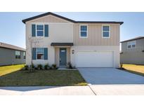 Inviting two-story home with blue shutters, a well-maintained lawn, and a two car garage at 2122 Rosewood Dr, Bartow, FL 33830